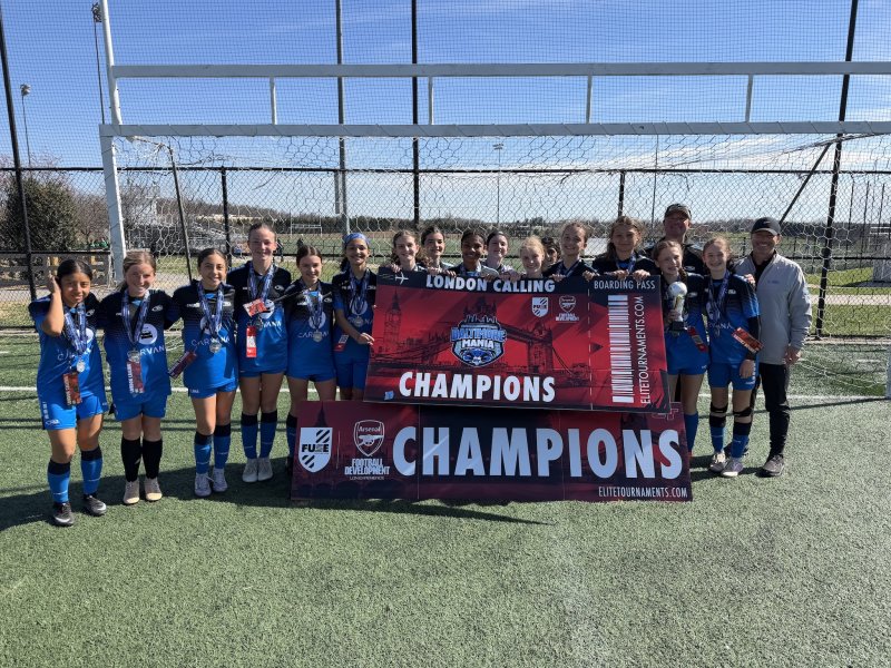 The Delmarva Rush 2012 Girls celebrate their second consecutive Baltimore Mania championship, earning an exclusive invitation to train in London with Arsenal F.C. Shown are in back (l-r) coach Scott Bleile and assistant coach Ritchie Thurman. In front are Maggie Roblero-Chavex, Finley Hurd, Sophia Santini, McKinley Adams, Madeleine Affayroux, Tejal Pillai, Natalie Adkins, Madeline Hill, London Nichols, Charlotte Gilman, Adelyn Thurman, Adriana Lopez, Garrity Cox, Isabella Iarussi, Eva Piper and Sadie Strumpf. SUBMITTED PHOTOS